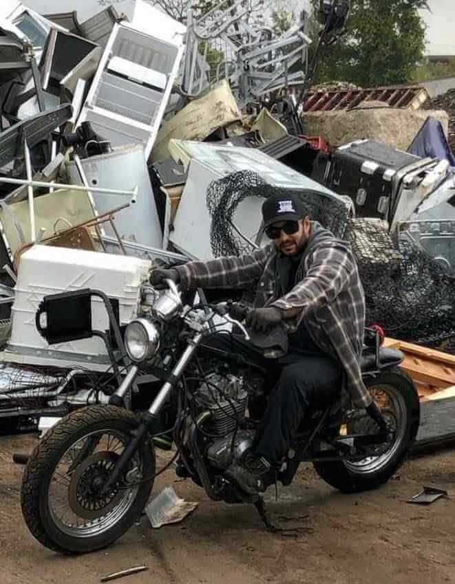 Christopher Sousa owner of Scrap Away Metal Recycling on motorbike in front of scrap metal yard